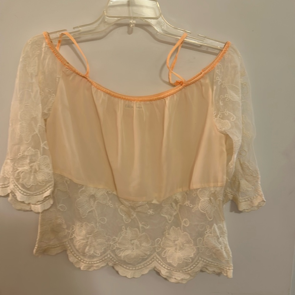 Lace cream top with peach trim. In good condition and is a size small.